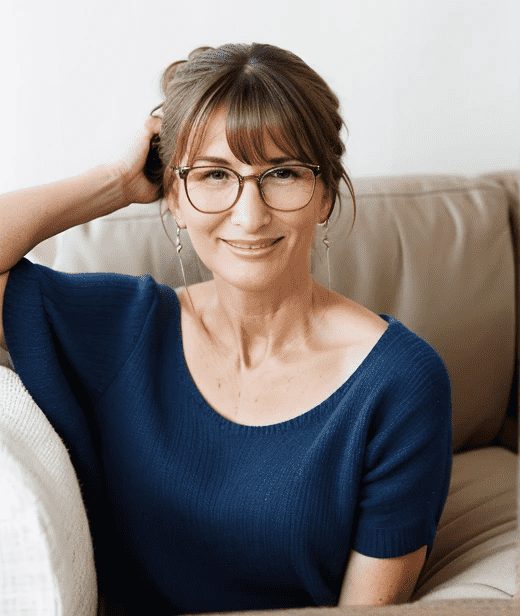 Elegant woman over 60 with glasses, sporting a casual bun with bangs, combining comfort and style for a relaxed yet refined look