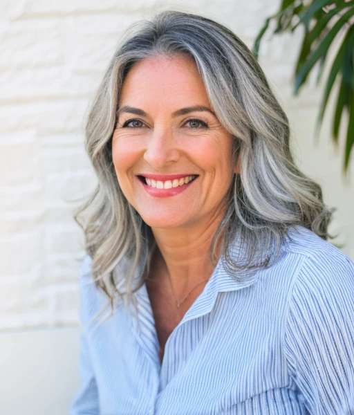 Long silver waves on smiling woman over 60