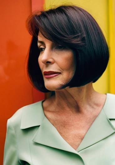 Sophisticated woman over 50 wearing an A-line bob with long side bangs, offering a sleek and contemporary look.